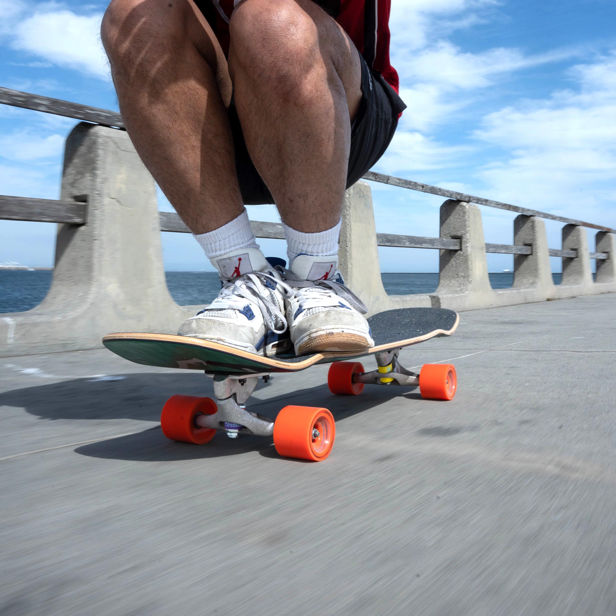 Person skateboarding on a concrete surface with a scenic background
