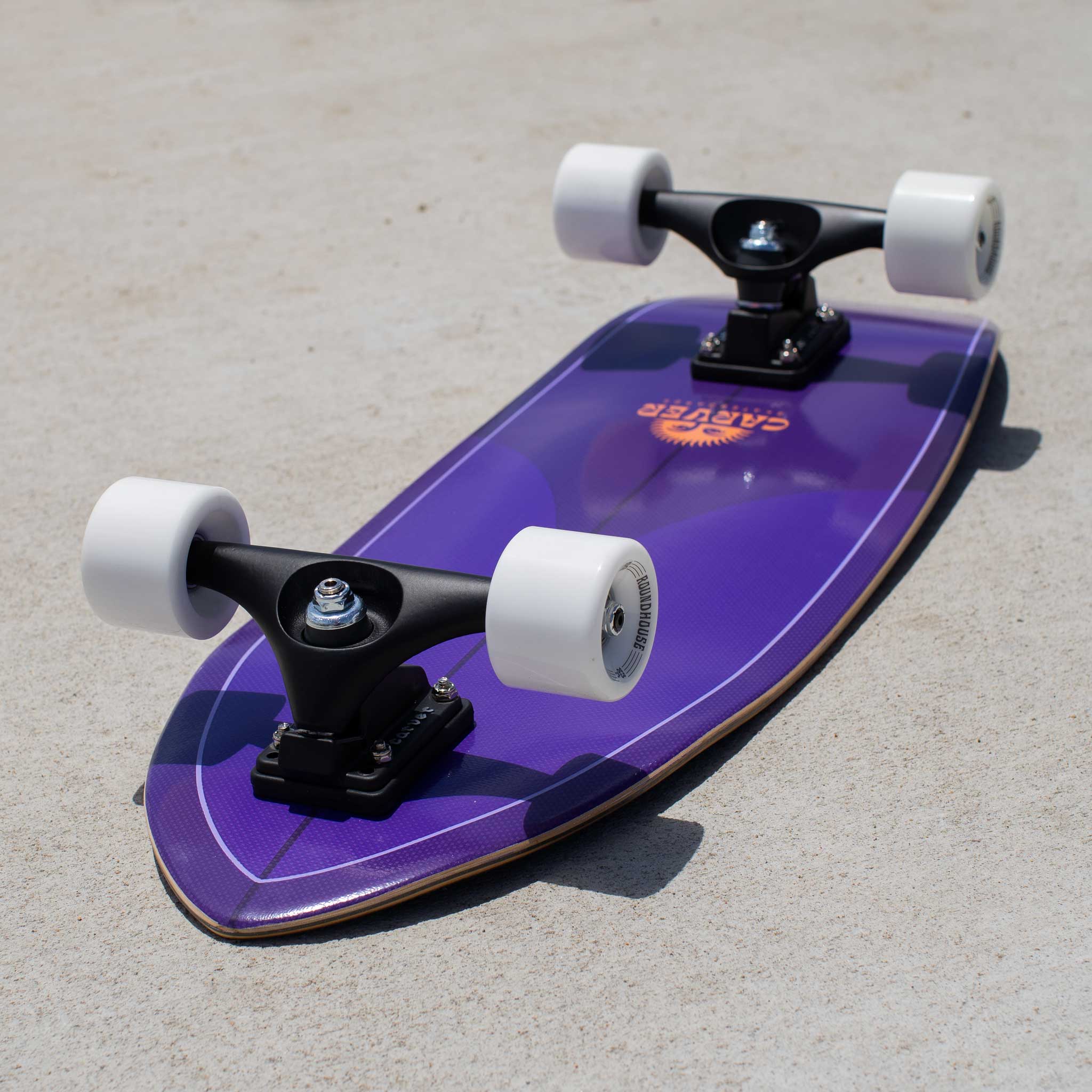 Carver Purple Haze mini surfskate skateboard with white wheels on a concrete surface
