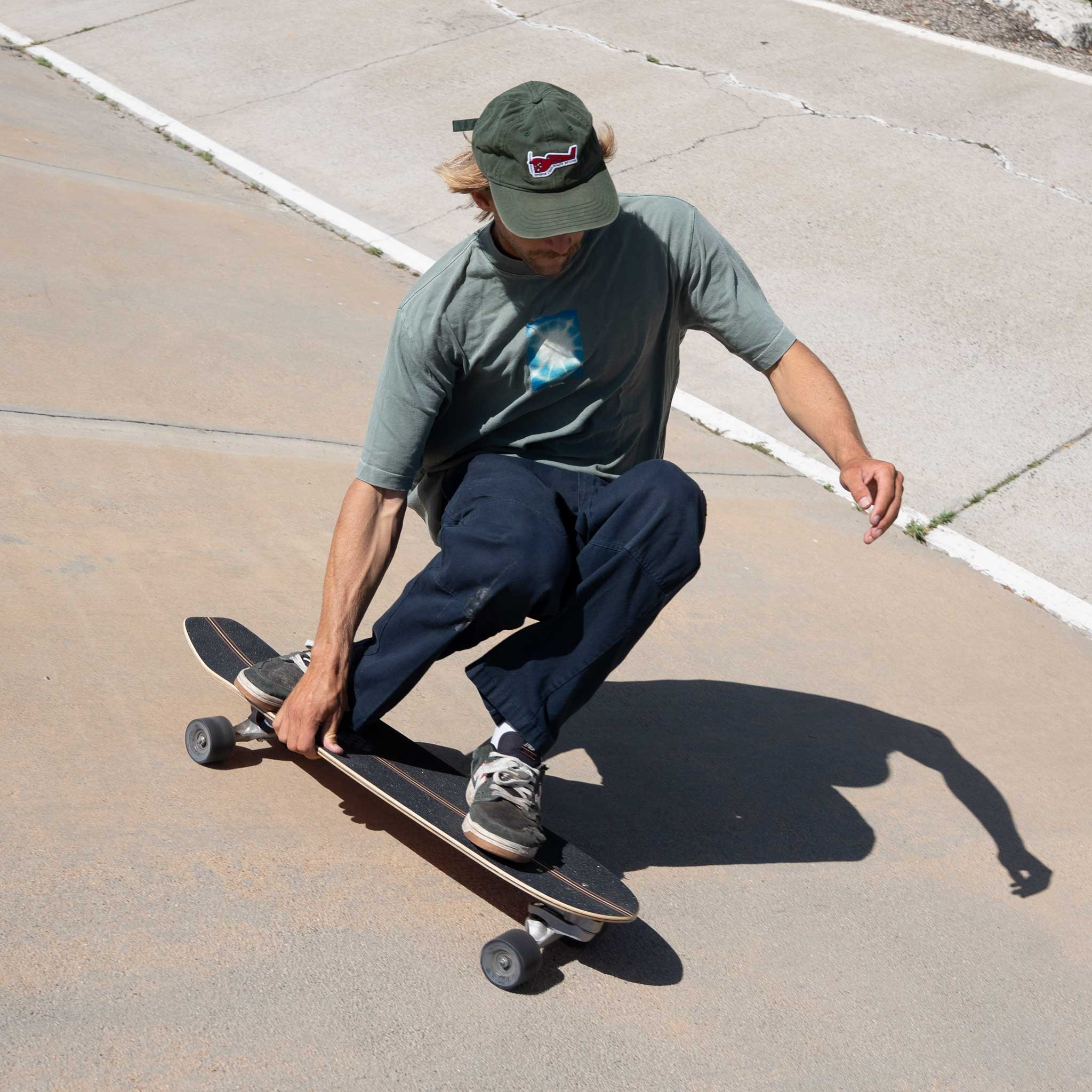 Person skateboarding on Carver CI Noserider surfskate on a sidewalk