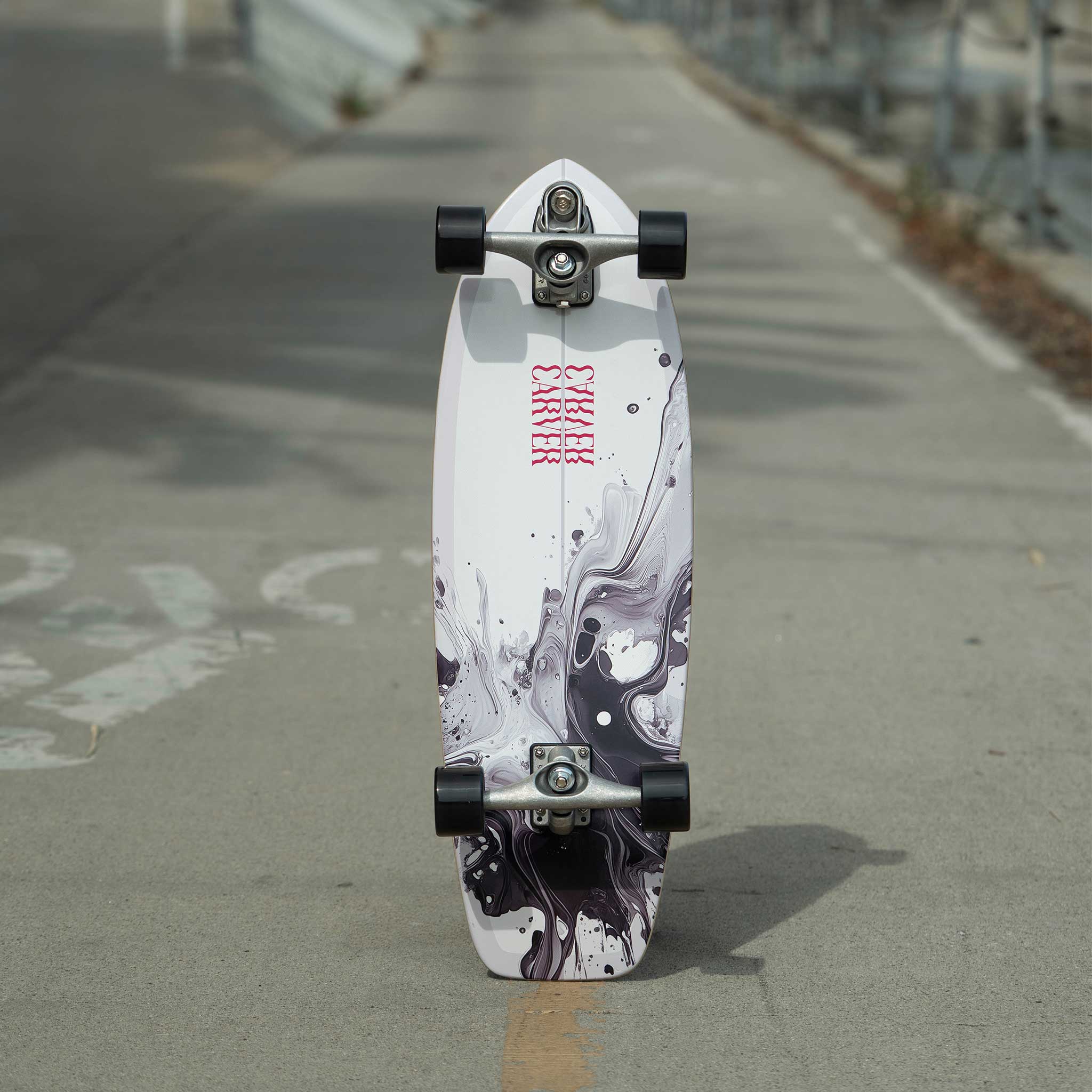 Skateboard with a white and black design on a concrete surface
